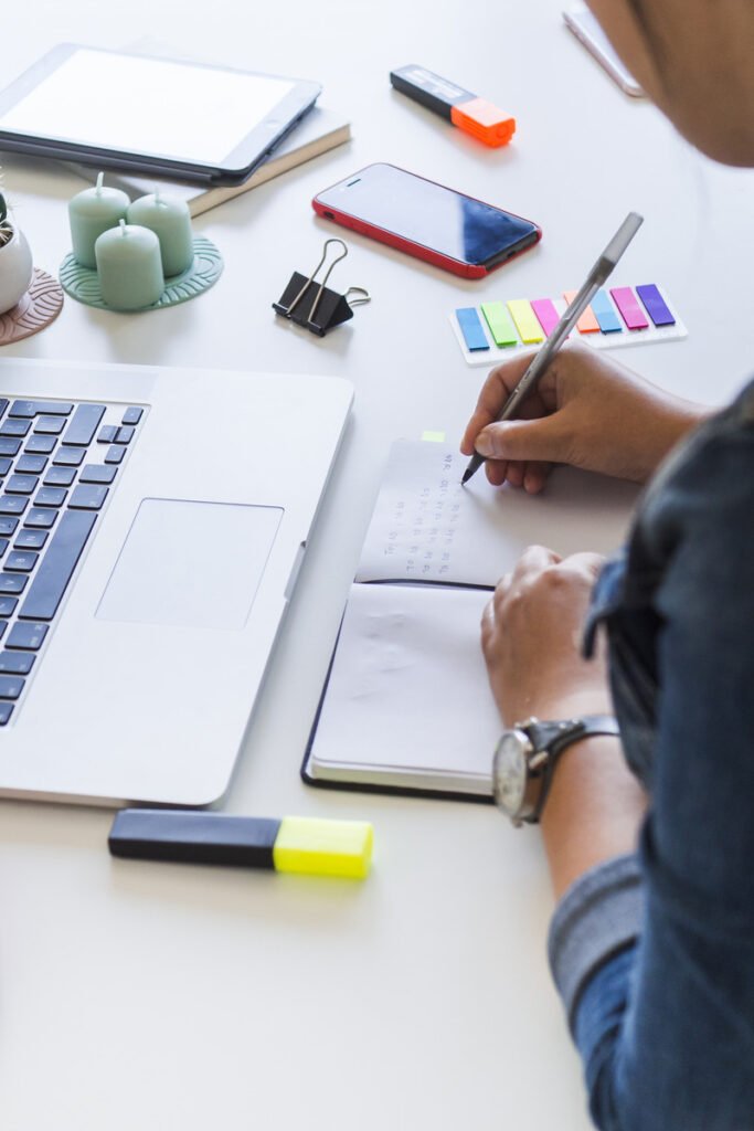 woman writing notebook table with laptop equipments 1